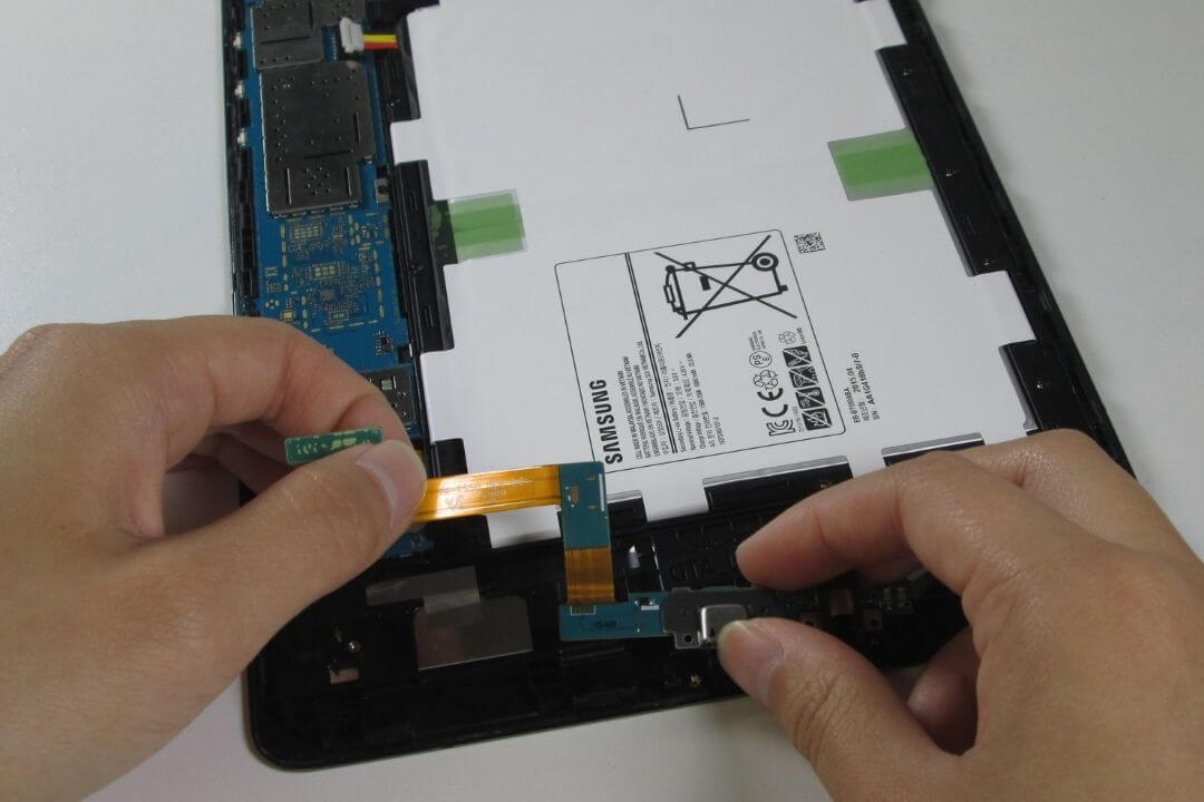 Close-up of a tablet charging port and circuit board